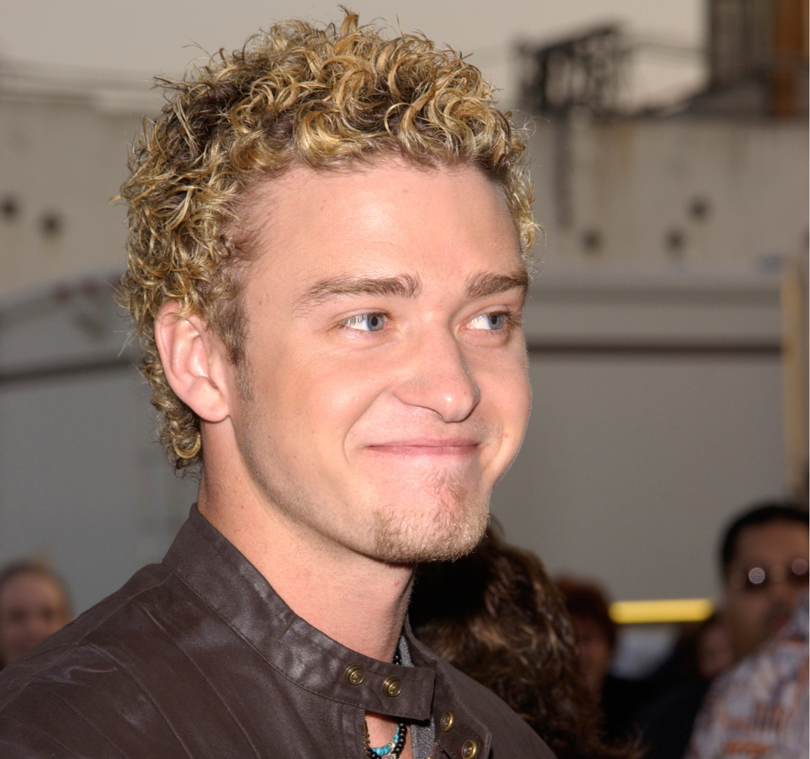 Justin Timberlake (met frosted tips) grijnzend op een première in een leren jasje