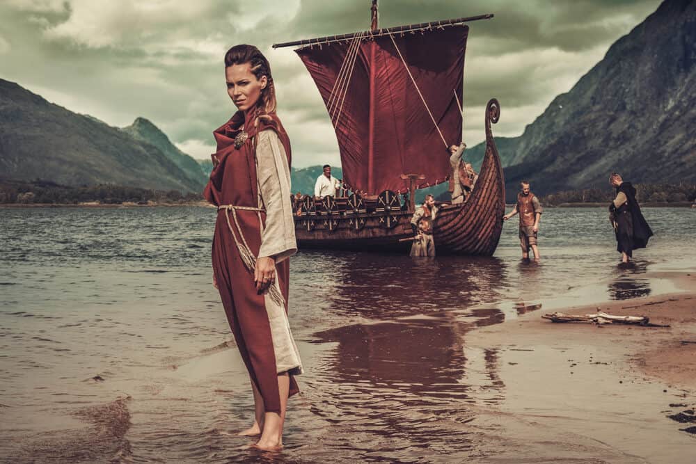 Schattige Viking vrouw met dreadlocks en oude haveloze kleding.