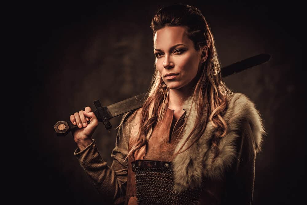 Een Viking vrouw gekleed als de Oude Egyptenaren met een bontjas en een zwaard.