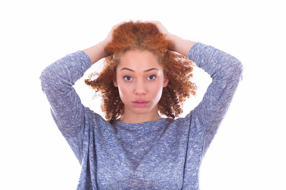 Een volwassen vrouw van gemengd ras van Keltische afkomst met krullend rood haar; het is ongewoon om gemberkleurig haar te zien bij zwarte vrouwen  