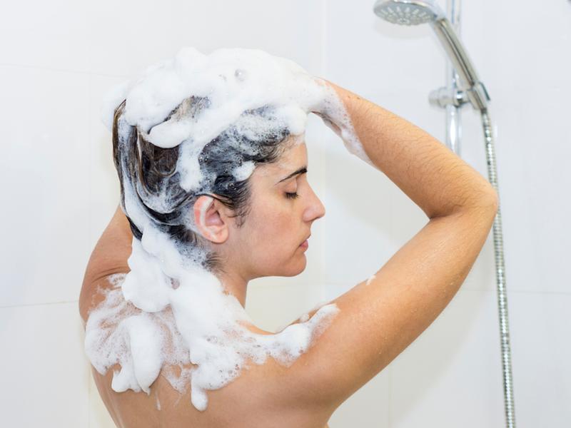 Vrouw gebruikt een shampoo met cocamide mea op haar haar