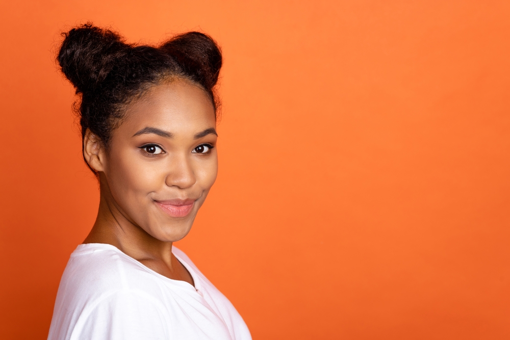 Coiled Space Buns op een schattig meisje van gemengd ras met krullend haar