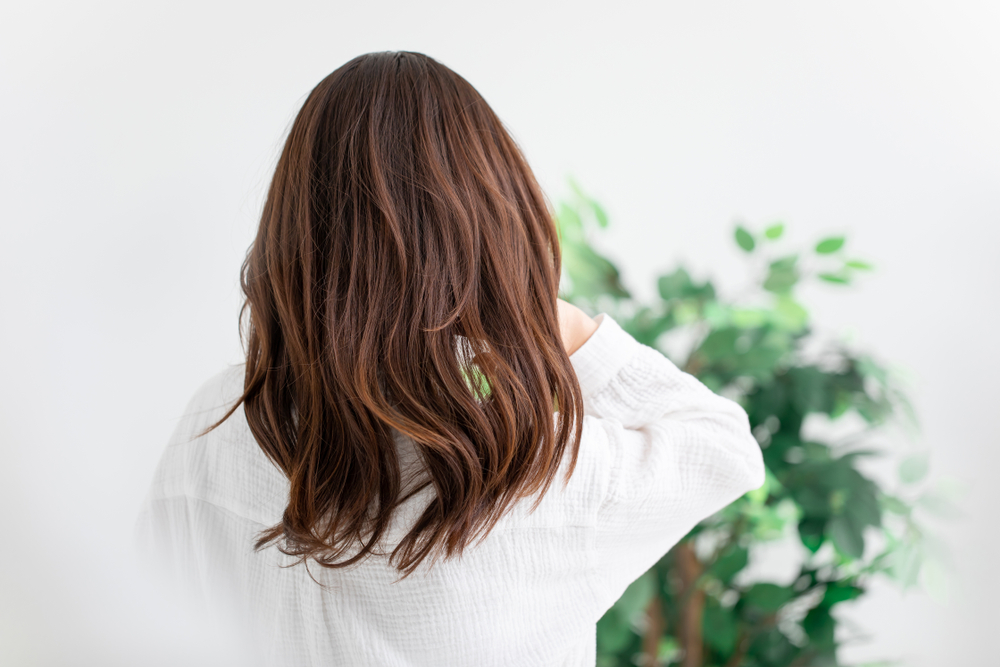 Vrouw die haar haar naar beneden draagt om een kapsel uit te laten groeien