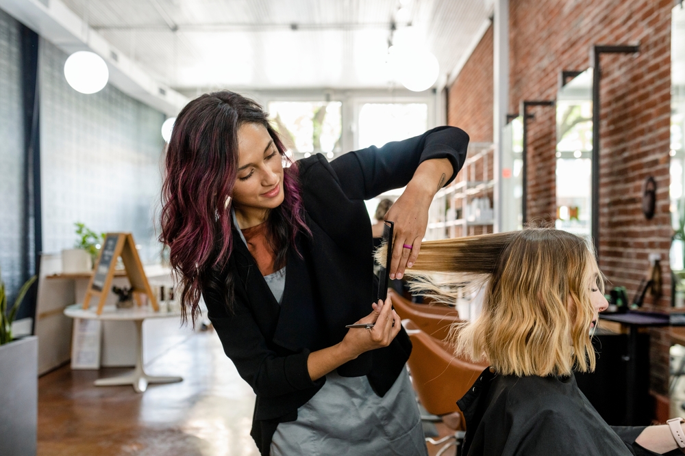 Vrouw die een knipbeurt krijgt in de salon voor een stuk over do split ends stop hair growth