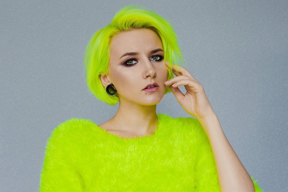 Neon Peridot Geel-Groen, één van de beste onnatuurlijke haarkleuren voor blauwe ogen, afgebeeld op een vrouw in een fel limoengroen shirt