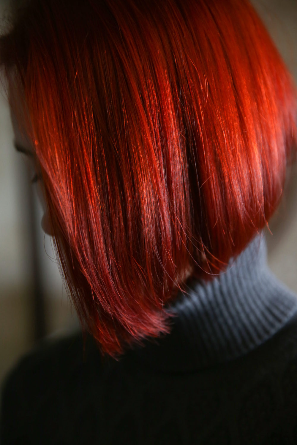 True Red haarkleur, een van de beste voor een bleke huid, op een vrouw in een coltrui