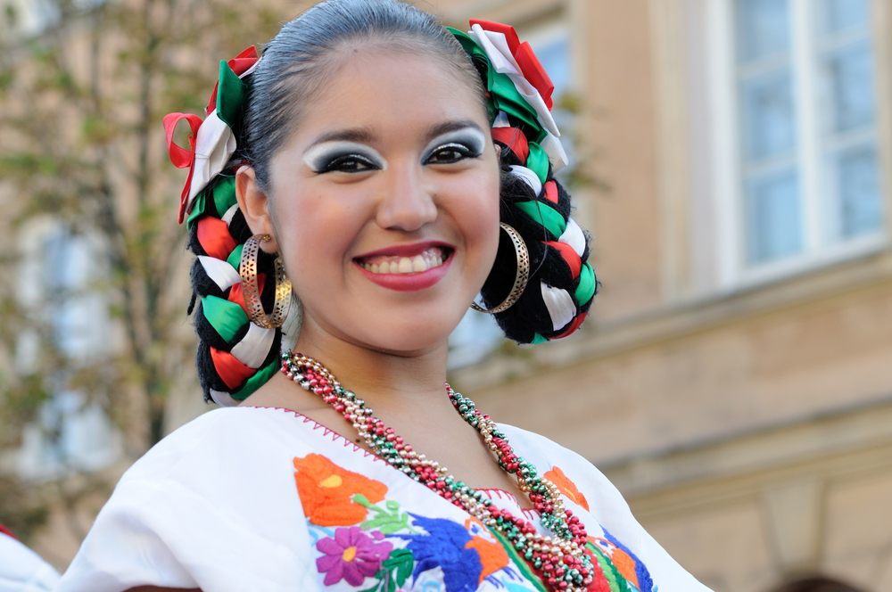 Vrouw met lus vlechten glimlacht voor een post op Mexicaanse vlechten ideeën