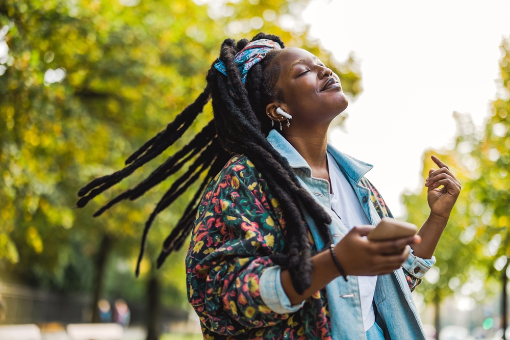 Thick, Distressed Faux Locs op een zwarte vrouw in een gebloemd shirt