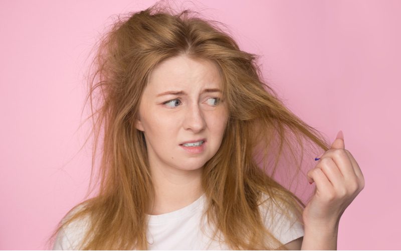 Vrouw met 1a haar houdt het vast en kijkt ernaar omdat het droog is