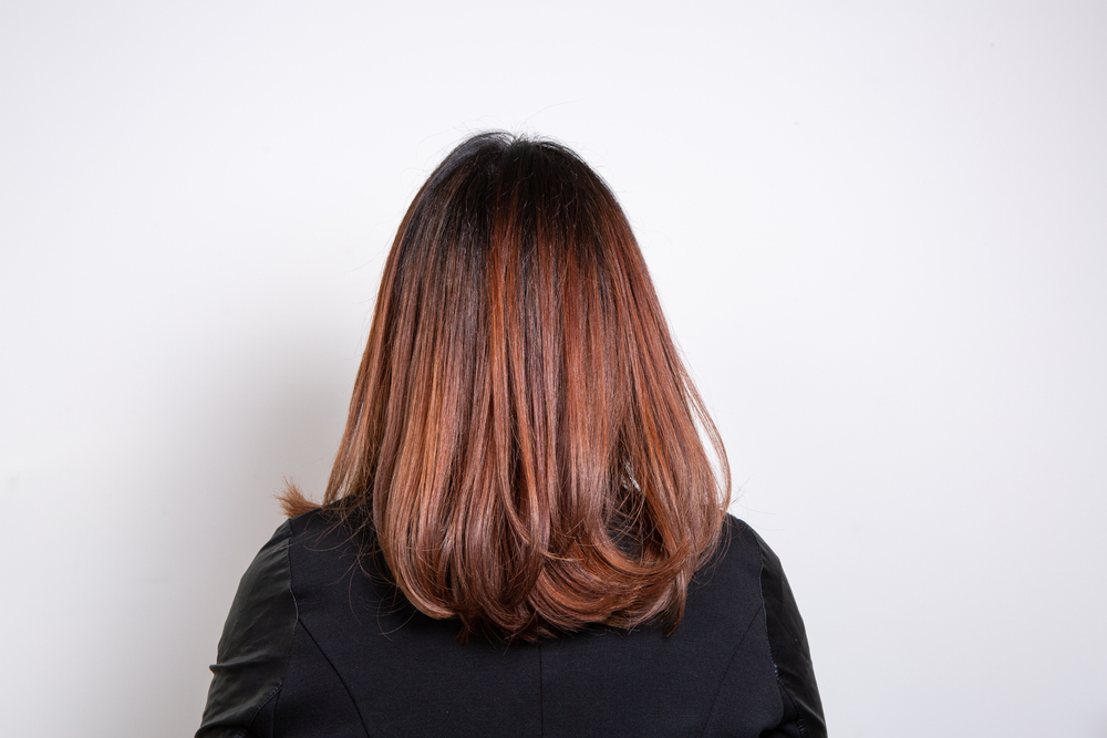 Lustrous Chestnut Balayage Red Brown Hair Color op een vrouw die van de camera wegkijkt