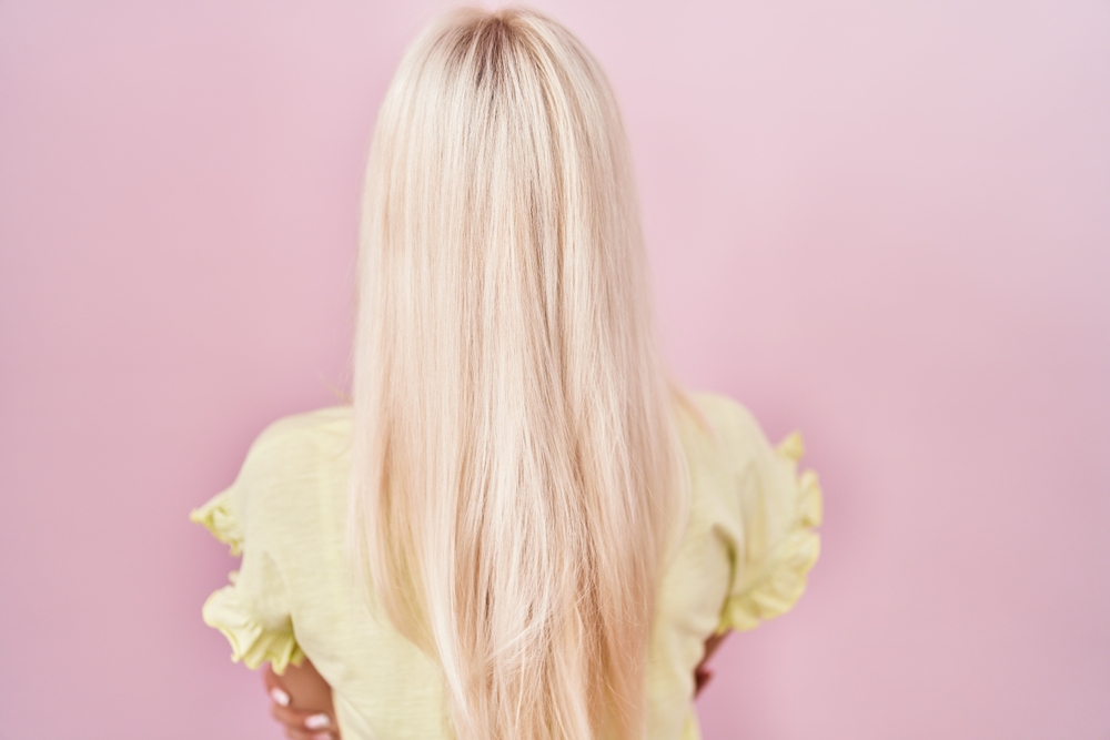 Voor een stuk over de beste zomer haarkleuren, draagt een vrouw Subtiele Roze-Toned Wit Blond kleur