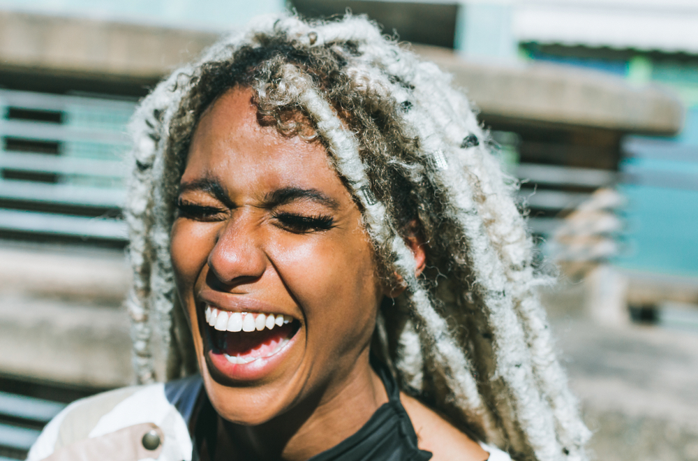 Vrouw lacht en vraagt zich af zijn dreadlocks vies