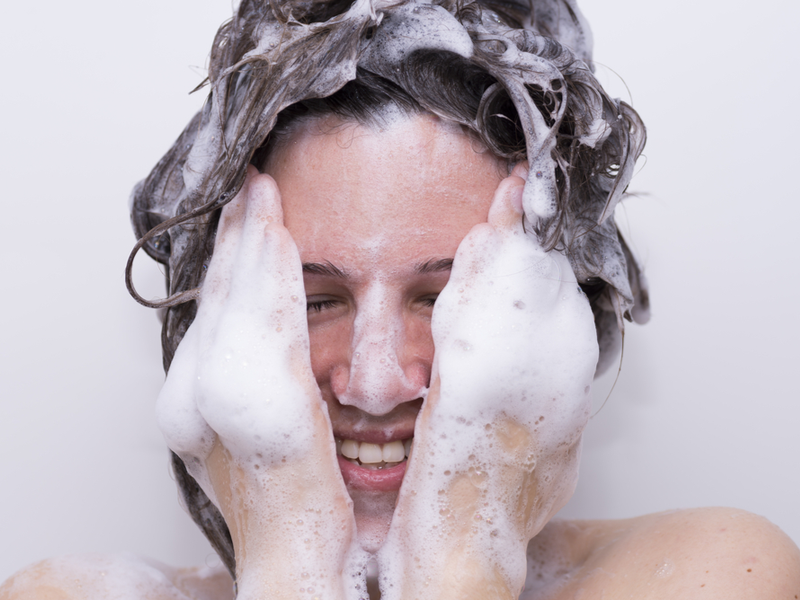 Vrouw die een shampoo gebruikt met laurylsulfaat erin