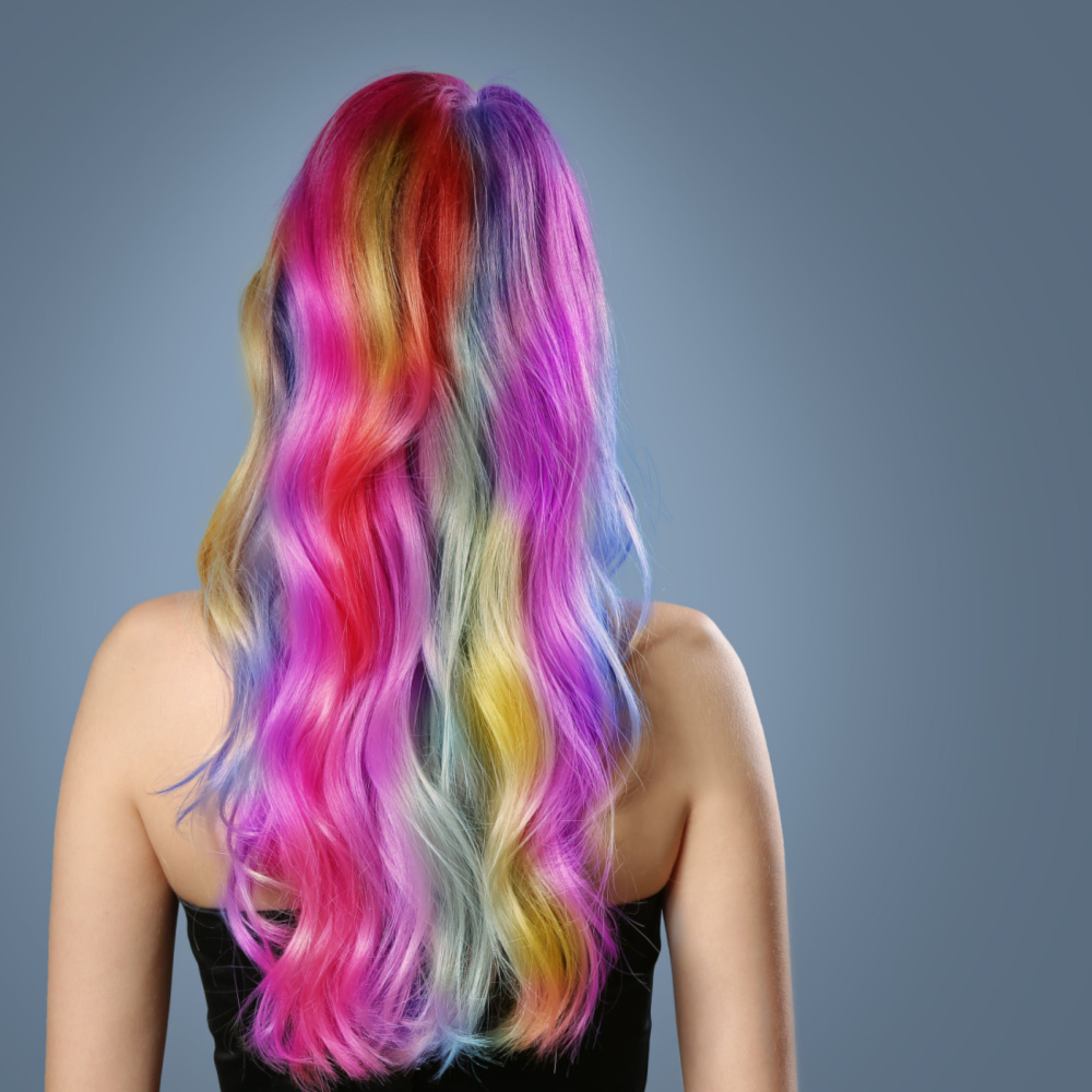 Vrouw met regenboog highlights afgebeeld als een idee van de beste haarkleuren voor neutrale huidskleuren