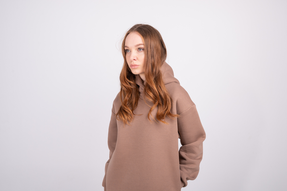 Vrouw in een hoodie met taupe haar, een voorbeeld van een onnatuurlijke haarkleur voor koele huidtinten