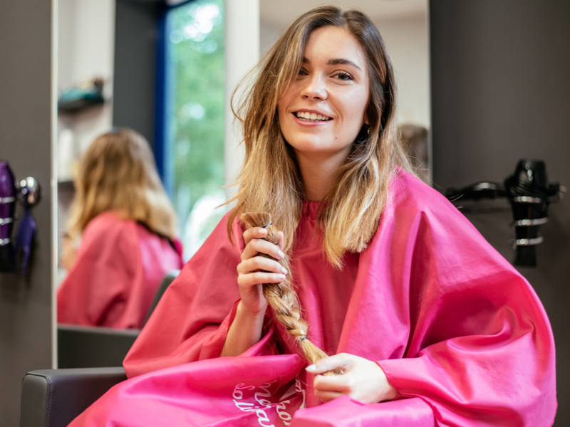 Vrouw houdt een stuk gevlochten haar voor een stuk getiteld hoe lang moet haar zijn om te doneren