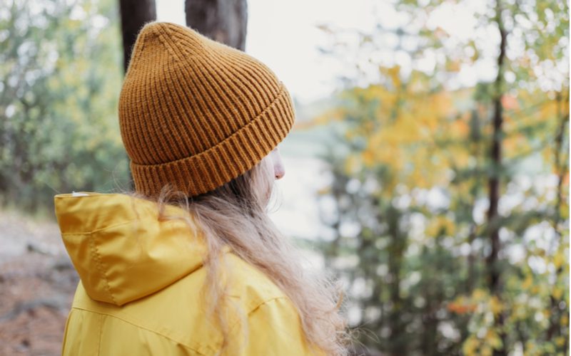 Vrouw draagt een muts omdat haar haar vet is en ze vraagt zich af waarom