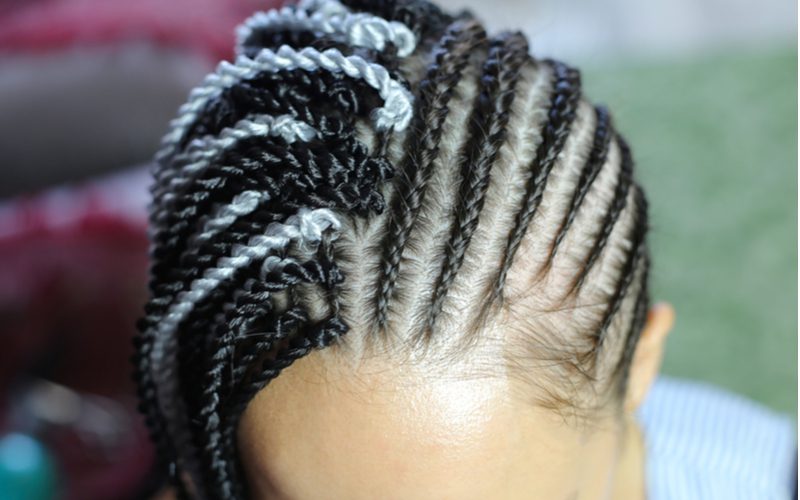 Vrouw met box braid extensions genaaid in het haar voor een stuk over hoe lang gaan haarextensies mee