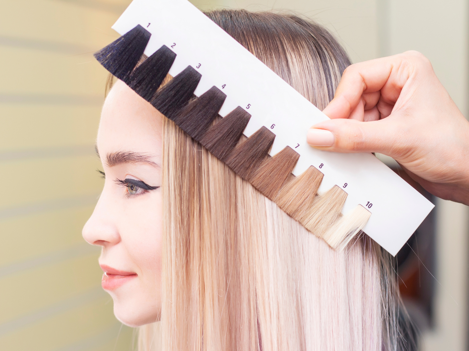 Vrouw gebruikt de kleurenwiel haartheorie om tinten te vinden die bij haar passen door geverfd haar tegen haar hoofd te houden.