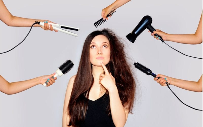 Om te illustreren hoe lang een blowout duurt, een vrouw met kroeshaar aan de ene kant en steil lang haar aan de andere kant en haartools die rond haar hoofd zweven.