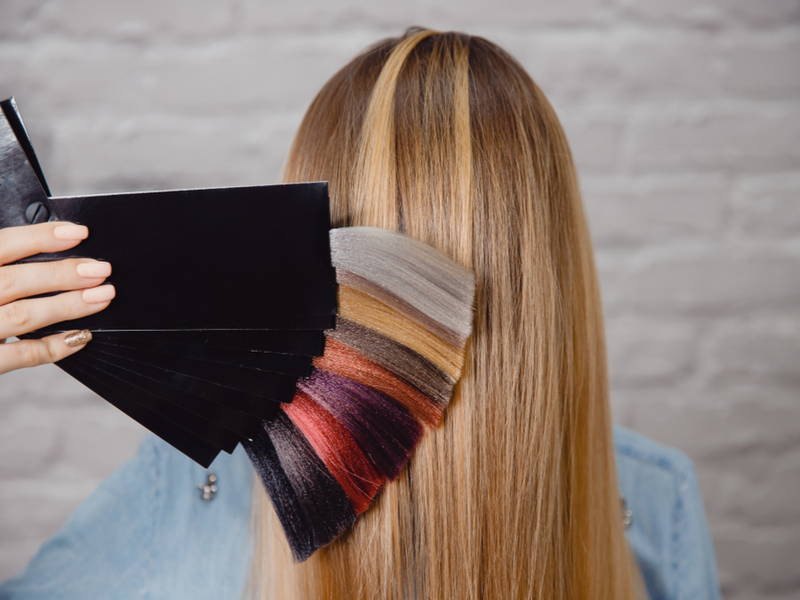 Vrouw kiest een kleur voor de overgang van highlights naar balayage