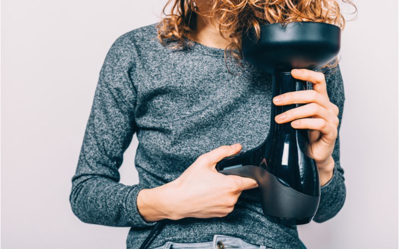 Vrouw gebruikt een diffuser om te laten zien hoe je krullend haar krult