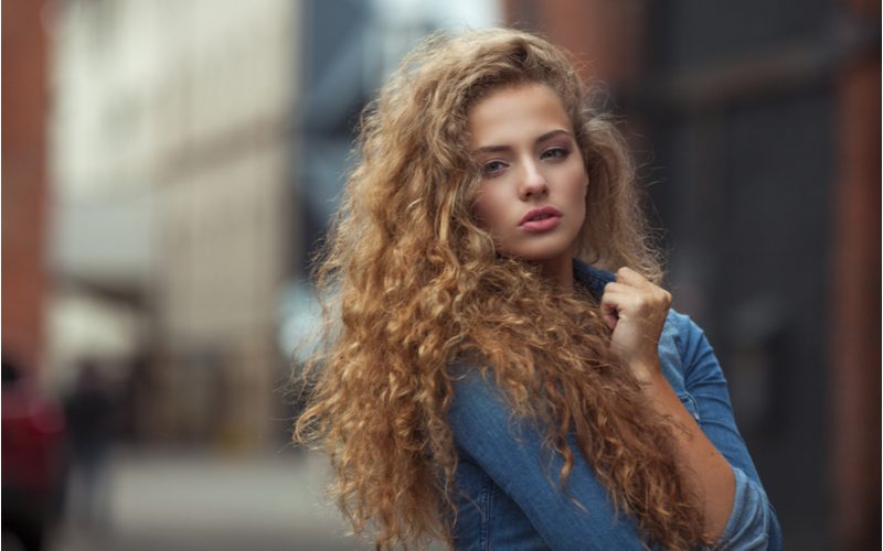 Prachtige jonge vrouw die moet leren hoe babyhaar te temmen