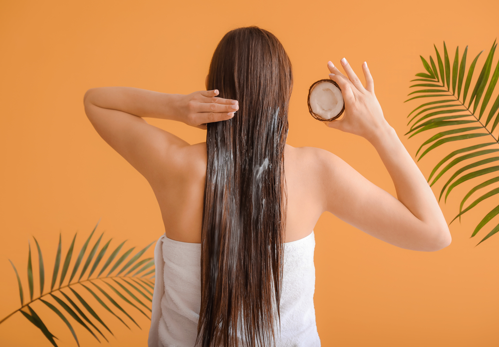 Vrouw gebruikt kokosolie op haar haar om de haarverf te verwijderen