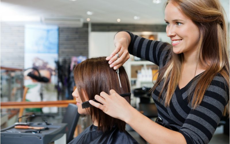 Vrouw wordt geknipt in een salon voor een stuk over wat een trimkapsel is