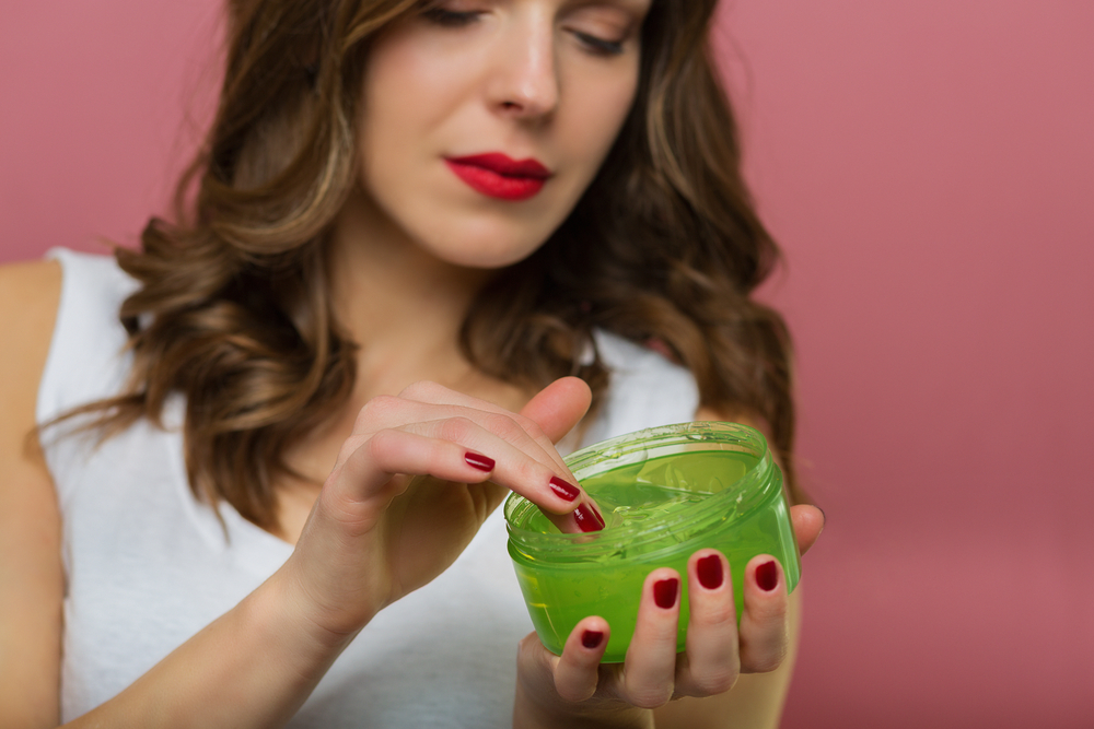 Vrouw die haargel, een van de beste alternatieven voor haarlak, op haar vinger aanbrengt om op haar haar aan te brengen