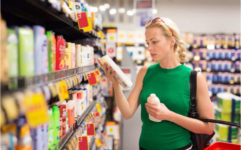 Vrouw kijkt naar verschillende opties om paarse shampoo te gebruiken op droog haar