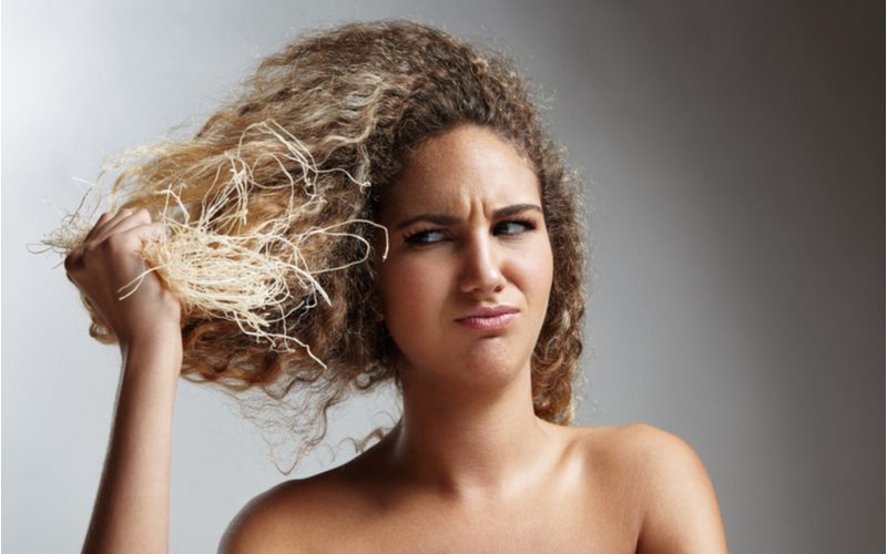 Blonde vrouw met beschadigd haar omdat ze het te snel na het bleken heeft geverfd