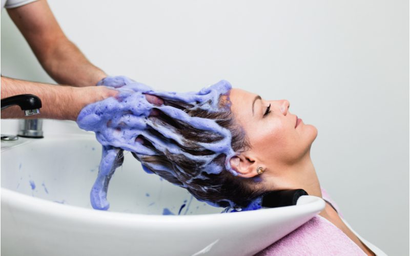 Vrouw krijgt groene kleurstof uit haar haar met zuiverende shampoo