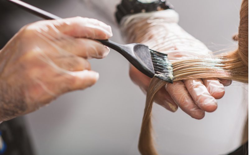 Vrouw draagt handschoenen zodat ze niet hoeft te leren wat permanente haarverf van de huid verwijdert