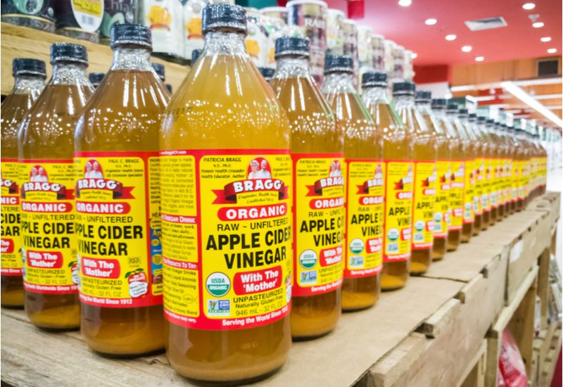 Veel flessen appelcider azijn staan in grote rijen op een pallet...