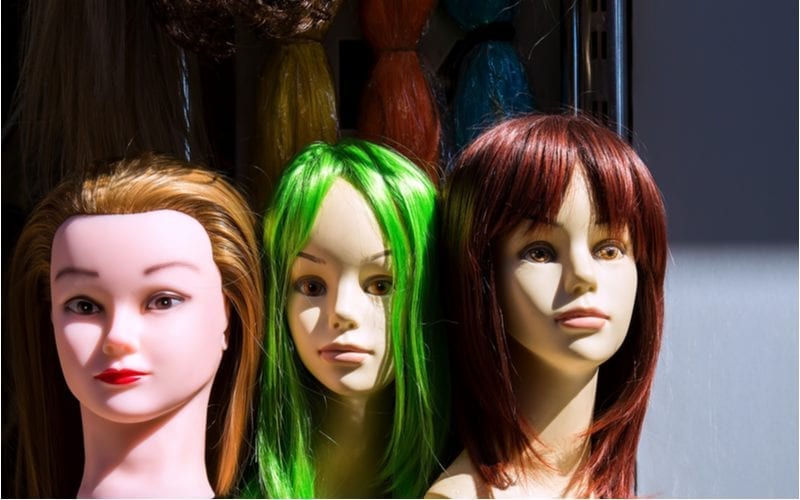 Pruiken op een mannequin in verschillende kleuren voor een stuk over wat is semi-permanente haarverf
