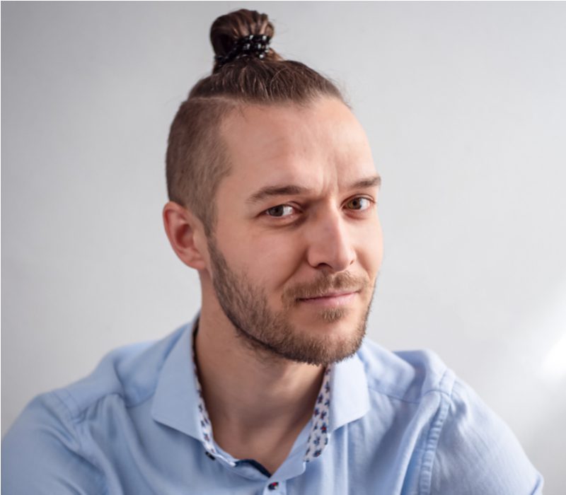 High Undercut Top Knot man bun op een man in een blauwe button-up shirt