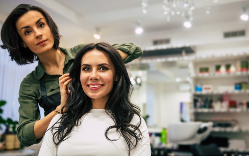 Lange Blowout Lagen op een vrouw in een wit shirt in de kapsalon