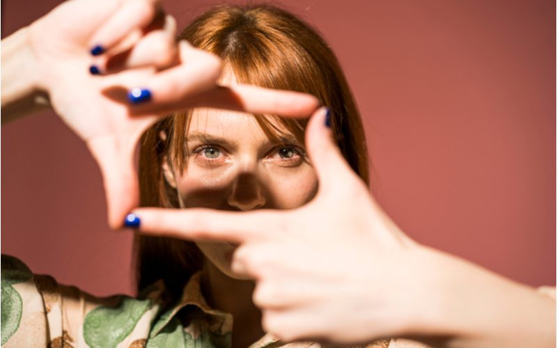 Gelaatskader lagen op een vrouw die haar vingers in een doos houdt om lagen te symboliseren die het gezicht inkaderen.