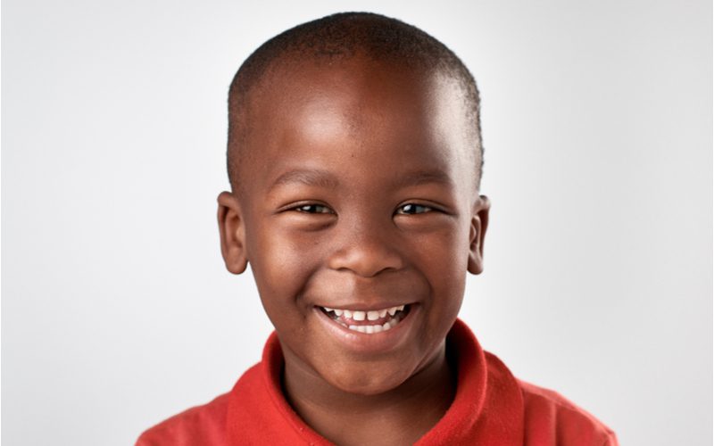 High Bald Fade als jongenskapsel op een zwarte jongen in een rood poloshirt