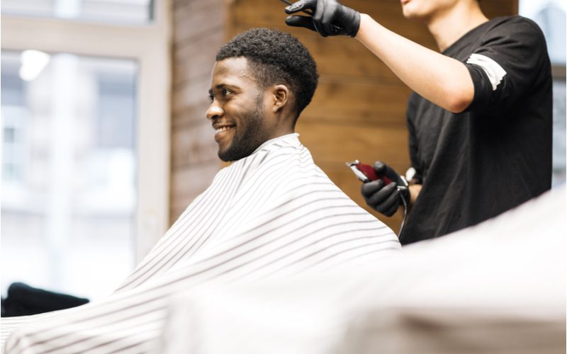 Wide-top mullet met fade op een zwarte man in een kappersstoel