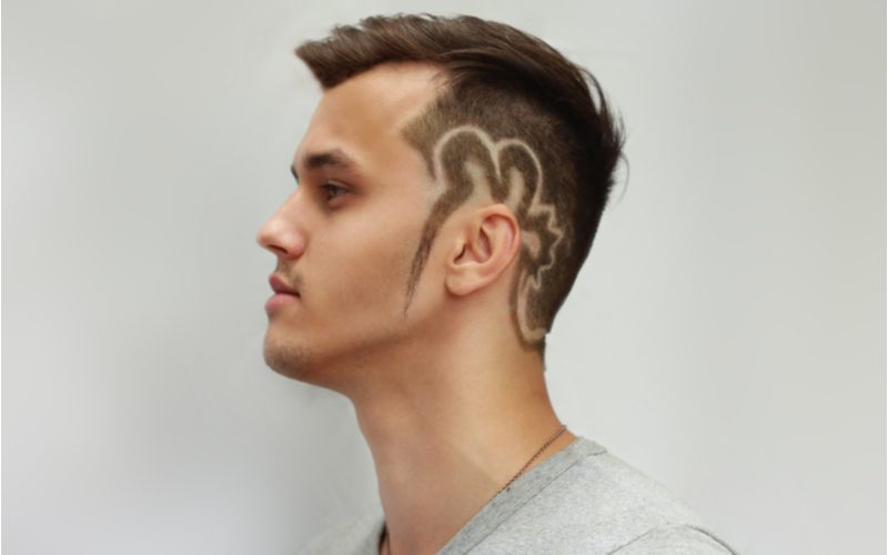 Mohawk Fade With Shaved Designs in een zijprofiel foto voor een stuk over populaire kapsels voor mannen