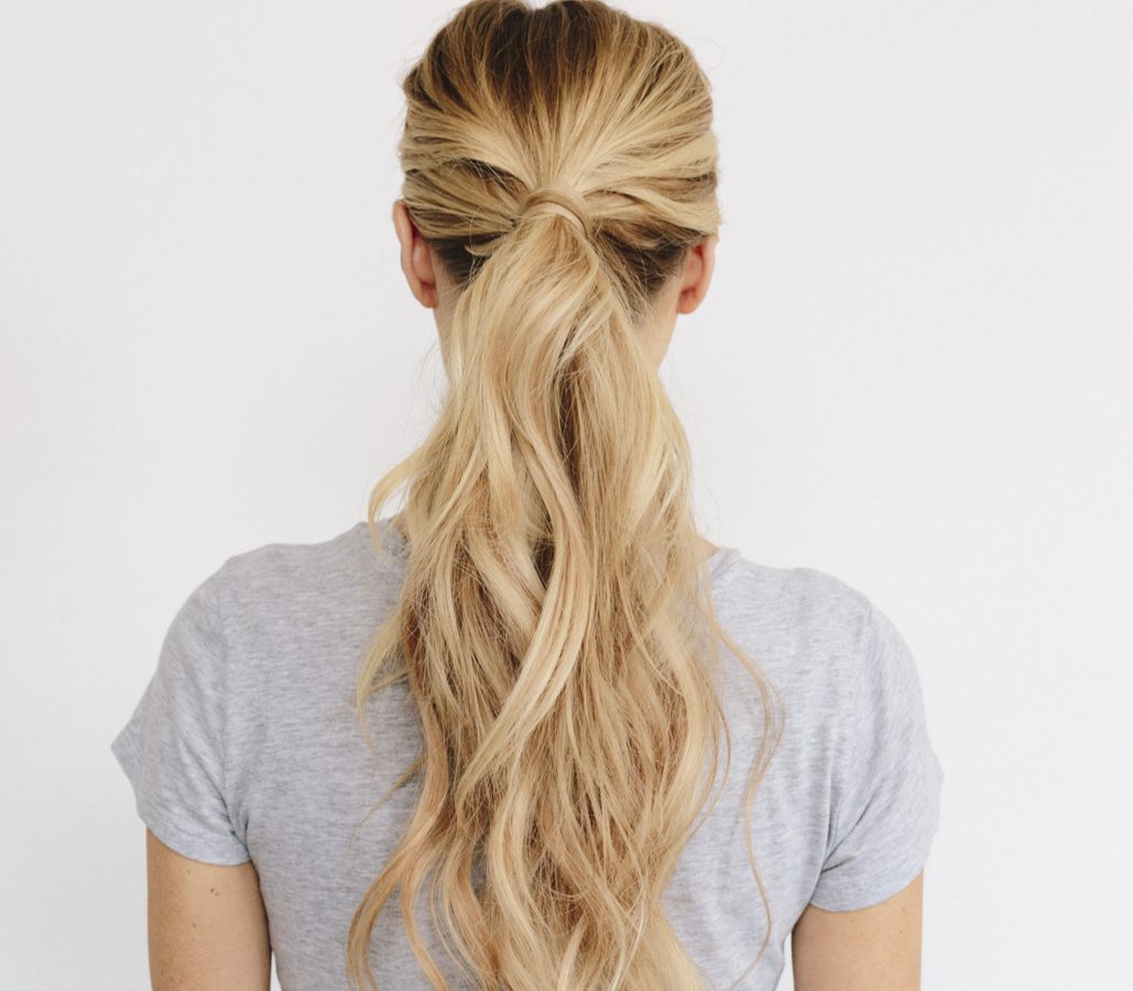 Messy Ponytail With Air-Dried Waves als een gemakkelijk dagelijks kapsel op een blonde vrouw in een grijs shirt