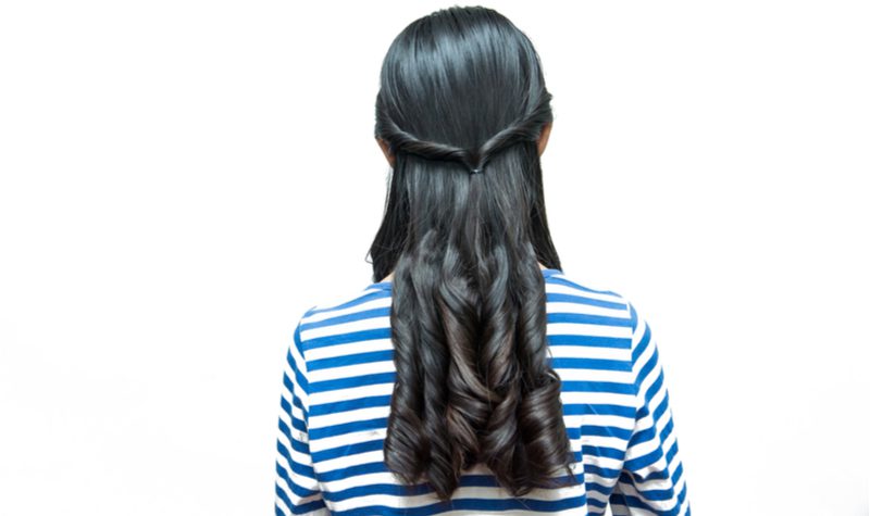 Half-Up Twists in rugprofiel op een vrouw in een blauw-wit gestreept jasje