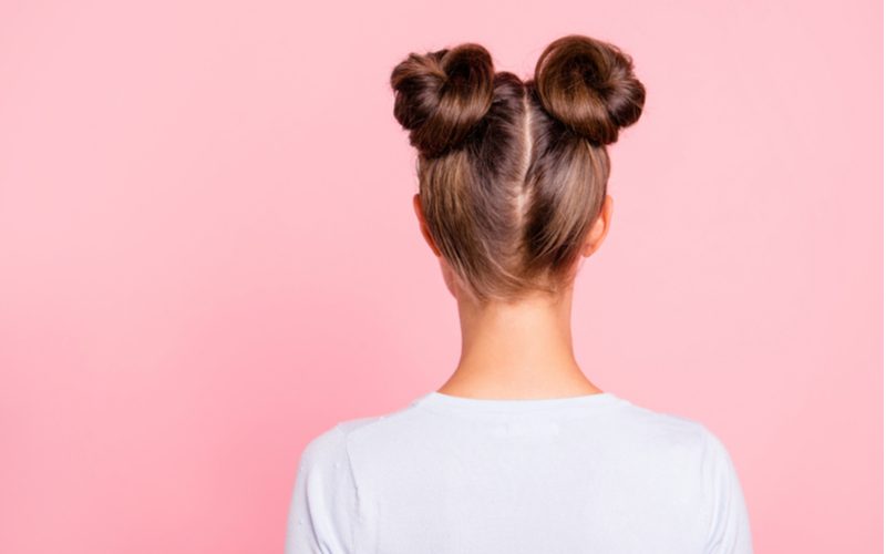 High Space Buns op een vrouw in een roze kamer als idee voor een gemakkelijk kapsel