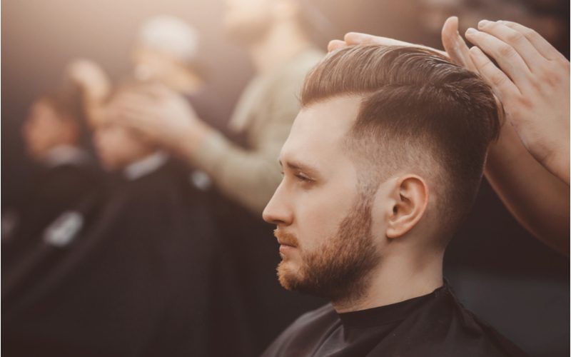 Man krijgt een mid fade met een pompadour