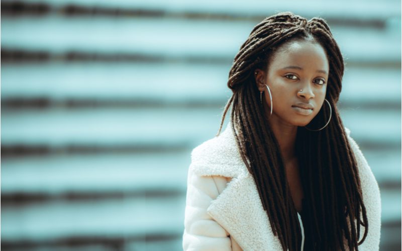 Long Half-Up Locs op een zwarte vrouw in een harige witte jas