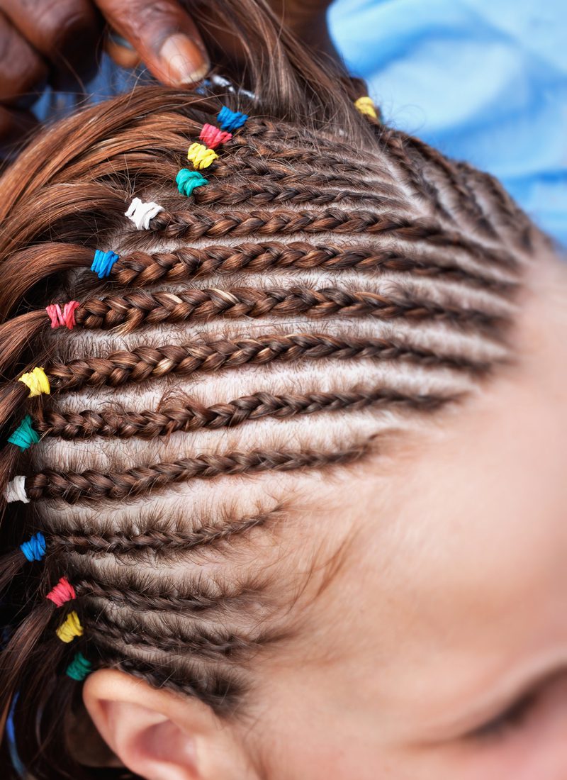 Blanke vrouw met tribale vlechten en meerdere gekleurde banden met strakke cornrows