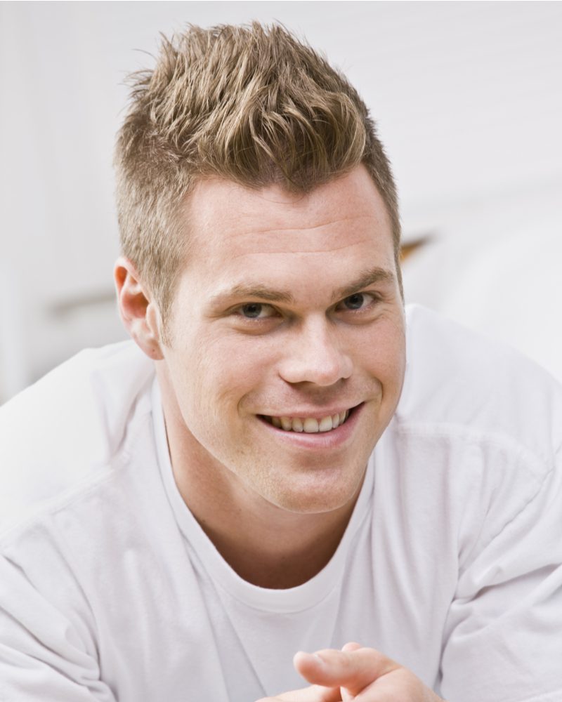 Klassieke Faux Hawk op een lachende man in een wit T-shirt met ronde hals.