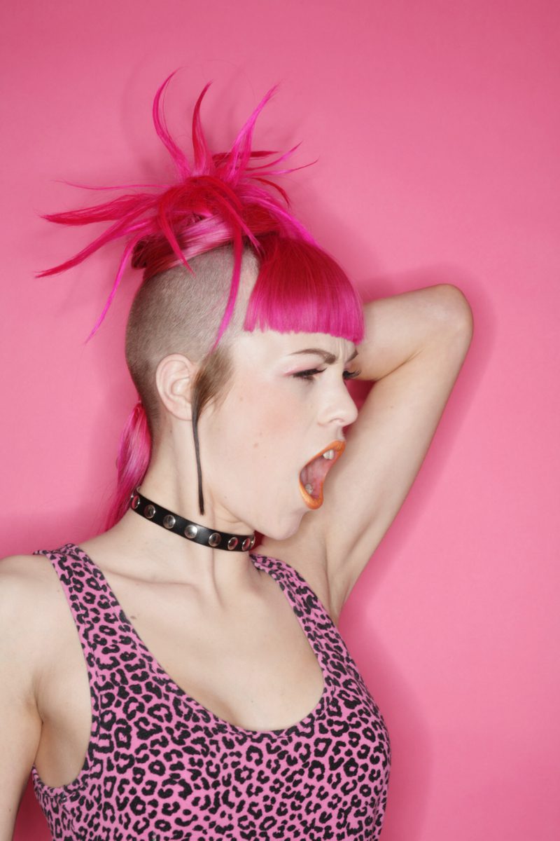 Fuschia Fringe punk kapsel gedragen door een vrouw in een roze cheetah print shirt